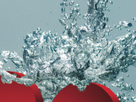 L'image montre des cercles rouges qui semblent plonger dans l'eau, provoquant des éclaboussures autour d'eux. Les bulles et les gouttes d'eau sont bien visibles, créant un effet dynamique et vivant. Le fond est en eau, ce qui accentue le mouvement de l'éclaboussure.