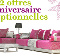 L'image présente un salon avec un canapé moderne et coloré. Le canapé est principalement en rose avec des coussins décoratifs aux motifs variés. Il y a également des touches de gris et de blanc, ajoutant une élégance à l'ensemble. L'arrière-plan est simple, ce qui met en valeur le mobilier. En haut de l'image, le texte indique "2 offres anniversaire optionnelles" en utilisant des couleurs vives, ce qui semble promouvoir une promotion spéciale.