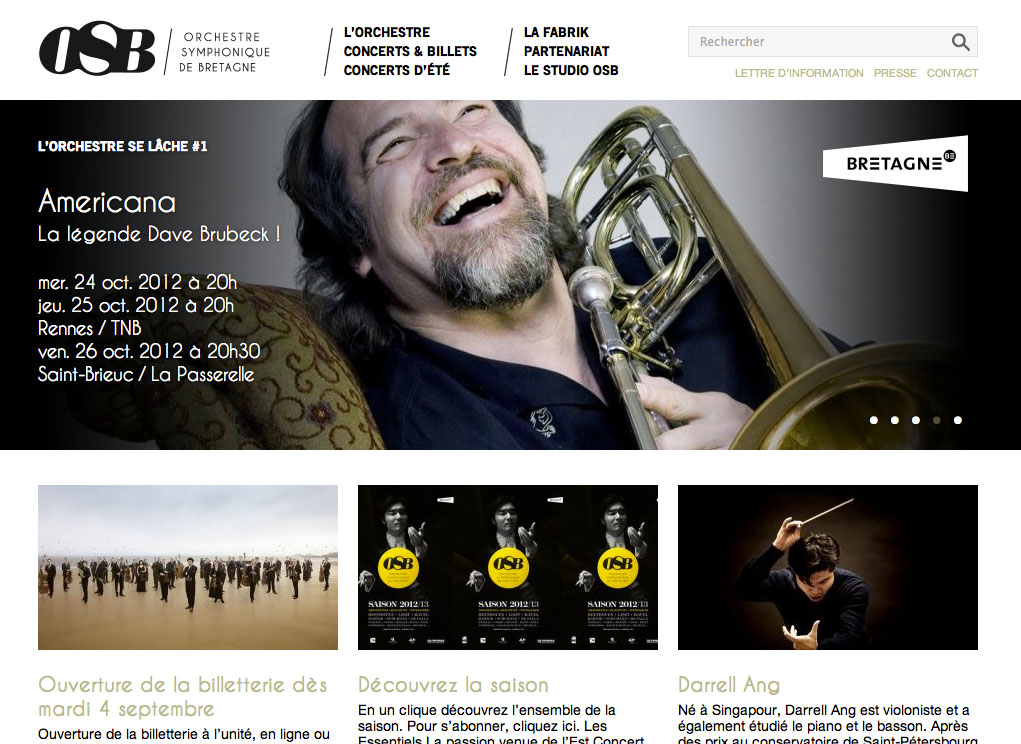 L'image semble être une capture d'écran d'un site web dédié à l'Orchestre Symphonique de Bretagne (OSB). En haut, il y a un titre mentionnant "L'orchestre se lâche #1" avec une référence à un concert appelé "Americana" célébrant la légende Dave Brubeck. Des informations sur les dates des concerts, à savoir le 24 et le 25 octobre 2012, ainsi que les lieux de présentation, sont également affichées. En bas, il y a des sections pour l'ouverture de la billetterie, des informations sur la saison et un artiste invité nommé Darrell Ang. L'ensemble de la présentation est à la fois attirant et informatif, évoquant l'ambiance d'un événement musical.