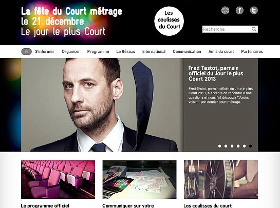 L'image présente un site web consacré à la fête du Court Métrage, qui a lieu le 21 décembre. En haut, on trouve un titre coloré qui annonce l'événement. La page semble comporter diverses sections, comme "S'informer", "Organiser", et "Le Réseau". Au centre, il y a une photo d'un homme en costume, tirant une cravate, accompagné d'une description le mentionnant comme parrain officiel de l'événement en 2013. En bas, il y a des éléments visuels comme des fauteuils de cinéma et des notes, suggérant des activités liées au court-métrage.
