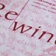 L'image présente un fond avec du texte en caractères rouges. On peut distinguer des mots tels que "rewind" et d'autres lettres, suggérant peut-être un thème lié à la mémoire ou à la révision. Le style de la police semble être moderne et l'ensemble donne une impression de composition graphique.