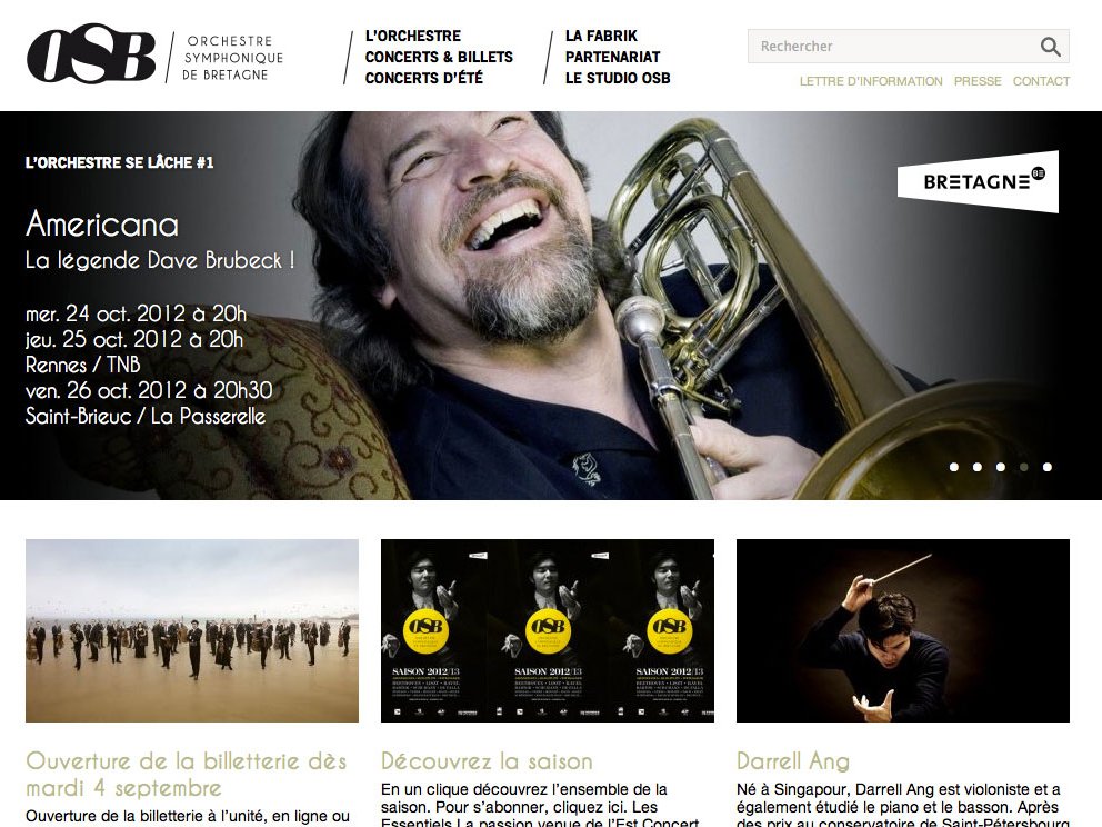 L'image semble être une capture d'écran d'un site web dédié à l'Orchestre Symphonique de Bretagne (OSB). En haut, il y a un titre mentionnant "L'orchestre se lâche #1" avec une référence à un concert appelé "Americana" célébrant la légende Dave Brubeck. Des informations sur les dates des concerts, à savoir le 24 et le 25 octobre 2012, ainsi que les lieux de présentation, sont également affichées. En bas, il y a des sections pour l'ouverture de la billetterie, des informations sur la saison et un artiste invité nommé Darrell Ang. L'ensemble de la présentation est à la fois attirant et informatif, évoquant l'ambiance d'un événement musical.