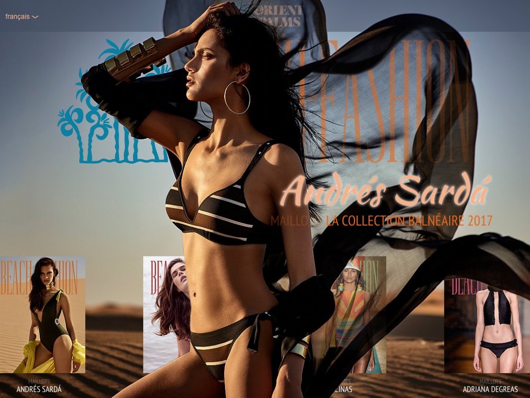 L'image présente une page d'accueil d'un site de mode, probablement consacré aux maillots de bain. On y voit une mannequin en maillot de bain noir et beige, avec une cape légère qui flotte autour d'elle. Le décor arrière-plan évoque un paysage désertique, qui ajoute une touche de chaleur et d'élégance à l'ensemble. Le texte en surimpression mentionne "Andrés Sarda" et "la collection balnéaire 2017", mettant l'accent sur une thématique estivale et chic. D'autres images de maillots de bain s'affichent en bas de la page.