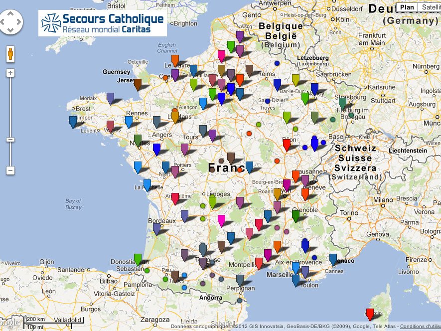 L'image montre une carte de la France et des pays environnants, avec plusieurs épingles de différentes couleurs. Chaque épingle semble représenter un emplacement lié à l'organisation "Secours Catholique". On peut voir des indications pour la Belgique et d'autres régions. La carte comprend des légendes et des informations géographiques, suggérant un réseau d'activités ou de points d'intérêt pour cette organisation. Les couleurs des épingles pourraient indiquer différentes catégories ou types d'initiatives.