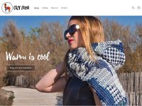L'image présente une page d'accueil d'un site web appelé "Cozy Lummi". Au premier plan, on voit une femme portant des lunettes de soleil et une écharpe en laine. Elle semble profiter du soleil, se tenant sur un chemin entouré de nature. En arrière-plan, il y a des arbres flous. Le texte en haut de l'image indique "Warm is cool" et invite à découvrir la première collection. Le design est moderne et accueillant, avec une mise en page claire et des couleurs apaisantes.